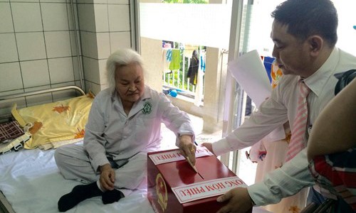 Bệnh viện Bạch Mai tổ chức bầu cử cho bệnh nhân tại phòng bệnh Cụ Nguyễn Thị Nga sinh năm 1937, Thanh Trì, Hoàng Mai, Hà Nội) bị thoái hóa khớp bỏ phiếu tại Hòm phiếu di động khoa Cơ xương khớp, BV Bạch Mai (Hà Nội).