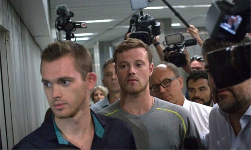 VĐV Mỹ bịa chuyện bị cướp dí súng vào đầu ở Olympic Gunnar Bentz (trái) và Jack Conger rời một đồn cảnh sát ở Rio hôm 18/8. Ảnh: AP.