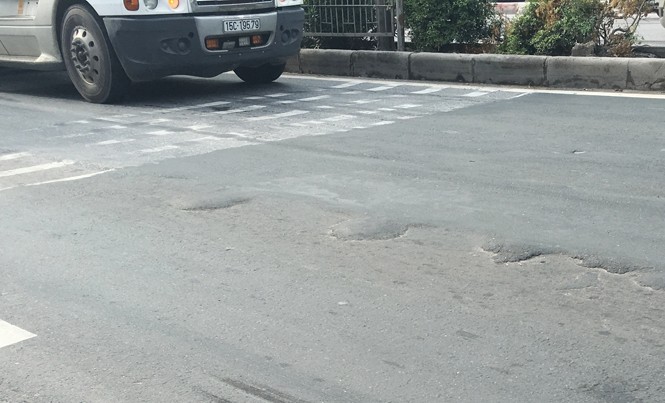 Dừng thu phí QL5 nếu không sớm “vá” mặt đường Sau khi bị thảm lại, mặt QL5 nhiều đoạn vẫn bị cào rách. Ảnh: A.Trọng.