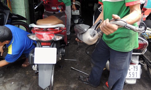 Xử lý đúng cách với xe ngập nước Thợ sửa xe tháo một ống xả bên trong chứa đầy nước.