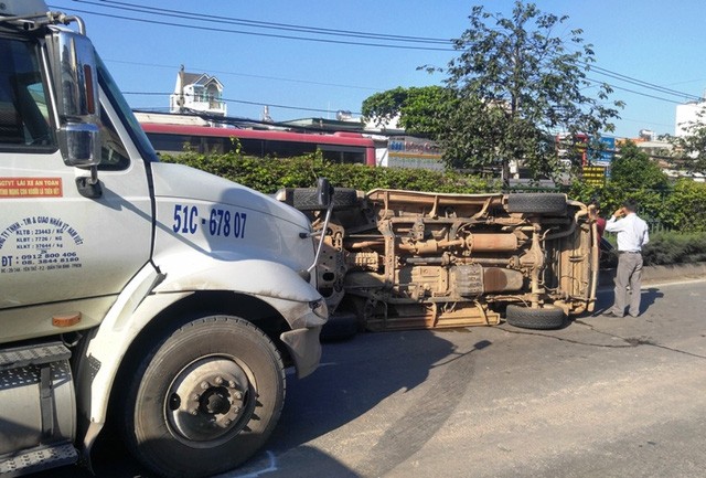 Ba người hoảng loạn bò ra từ chiếc ô tô lật Chiếc ô tô lật ngay trước đầu container.