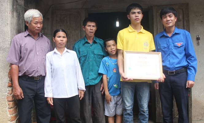 Tặng bằng khen, tiếp sức cho cậu học trò nghèo đạt 30 điểm Anh Lê Văn Châu - phó bí thư Tỉnh đoàn Thanh Hóa (bìa phải) tặng bằng khen cho em Lê Hữu Hiếu sáng 9/7. Ảnh: Hoàng Lam.