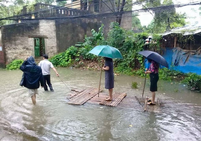 Chủ tịch phường đứng trên bè cho người kéo qua vùng nước ngập Chủ tịch phường đứng trên bè cho người kéo qua vùng nước ngập