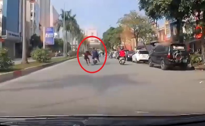 Bưng tô phở sang đường, người phụ nữ bị xe máy đâm ngã bất tỉnh Ảnh cắt từ clip.