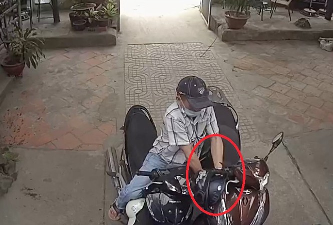 Hai thanh niên bình tĩnh trộm xe SH trong quán cà phê ở Sài Gòn Tên trộm bẻ khóa chiếc xe SH. Ảnh cắt từ clip.