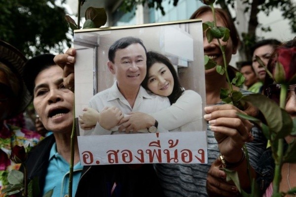 Bản tin 8H: Anh em cựu thủ tướng Yingluck xuất hiện tại Singapore Người ủng hộ cầm ảnh ông Thaksin và em gái Yingluck tại Bangkok hồi tháng 8/2017. Ảnh: AFP.