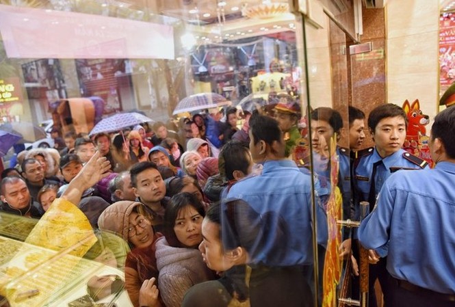 Bản tin 8H: Dân Hà Nội xếp hàng mua vàng ngày vía Thần tài Nhiều người đội mưa, che ô chờ kín đặc bên ngoài cửa hàng vàng.
