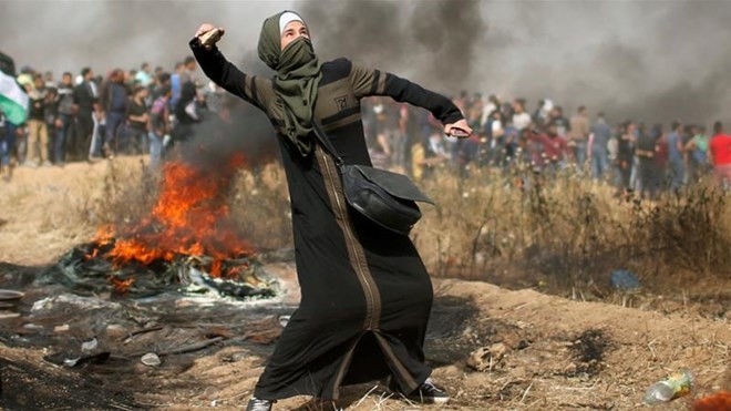 Bạo lực tiếp diễn tại Dải Gaza, hàng chục người thương vong Một phụ nữ người Palestine chống trả quân đội Israel. (Nguồn: Reuters)