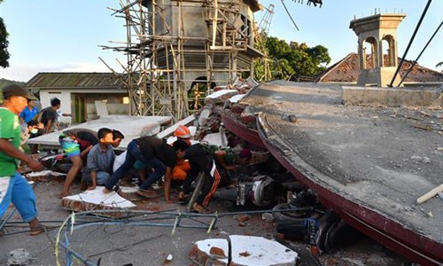 Lực lượng cứu hộ dùng tay đào bới cứu người trong động đất Indonesia Lực lượng cứu hộ và người dân tìm cách tiếp cận người còn sống và các thi thể dưới đống đổ nát trên đảo Lom bok hôm 5/8. Ảnh: Reuters.