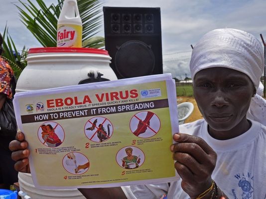 Dùng âm nhạc tuyên truyền đẩy lùi dịch Ebola Một người phụ nữ Liberia giơ tờ hướng dẫn chỉ cách phòng chống dịch Ebola.