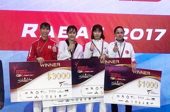 Nữ võ sĩ Việt Nam giành HCB Taekwondo Grand Prix thế giới Kim Tuyền (áo đỏ) trên bục nhận giải.