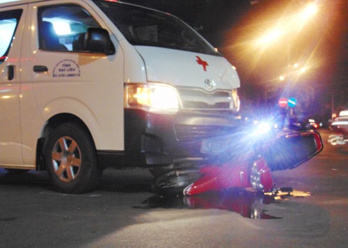 Ôtô cứu thương vượt đèn đỏ, húc thanh niên văng xa 5 mét Nạn nhân bị húc văng hơn 5 m, trọng thương; xe máy dính chặt vào phần đầu ôtô cứu thương.