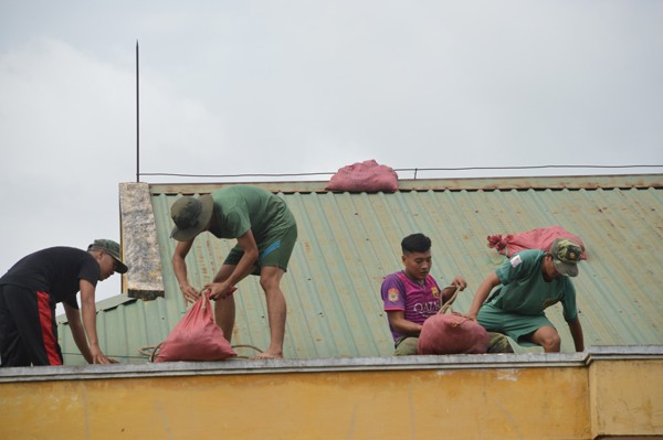 Sơ tán dân, cho học sinh nghỉ học trước khi bão số 16 đổ bộ Bộ đội giúp dân chằng chống nhà cửa phòng chống bão. Ảnh: Xuân Lương
