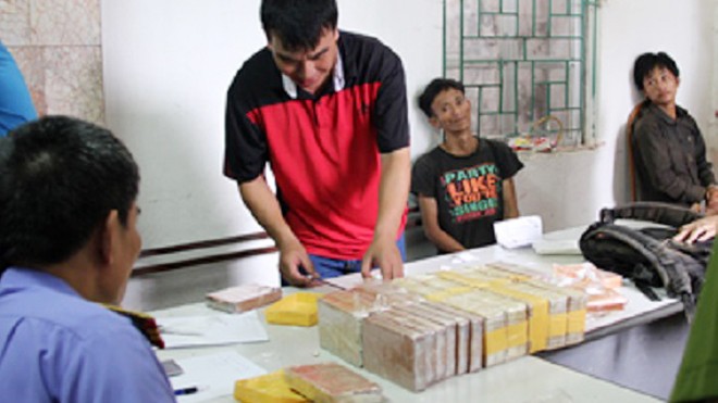 Hai người Lào vận chuyển 40 bánh heroin vào Việt Nam Công an khám nghiệm tang vật ma túy của hai đối tượng Tếnh và Chứ.