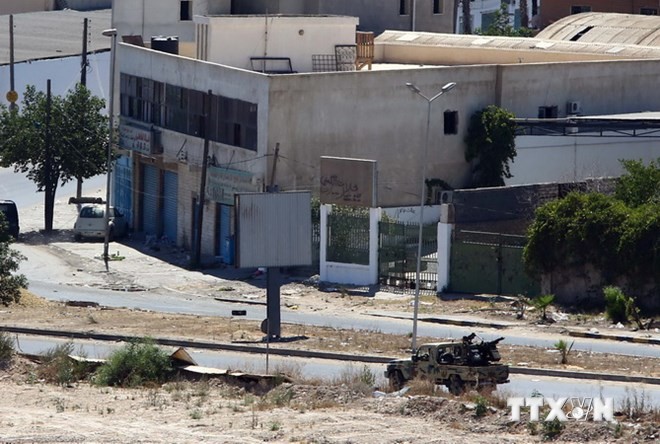 Bản tin 20H: Chính phủ Libya cảnh báo sụp đổ đất nước Xe quân sự chở vũ khí hạng nặng được sử dụng trong cuộc giao tranh gần tuyến đường tới sân bay Tripoli ngày 20/7. Ảnh: AFP-TTXVN