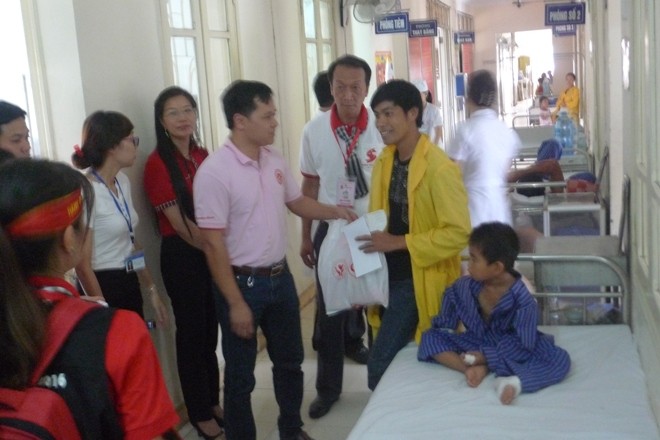 Chạy chơi trong nhà, bé trai bị chó cắn suýt chết Các nhà hảo tâm động viên cháu Dũng. Ảnh: Duy Chiến
