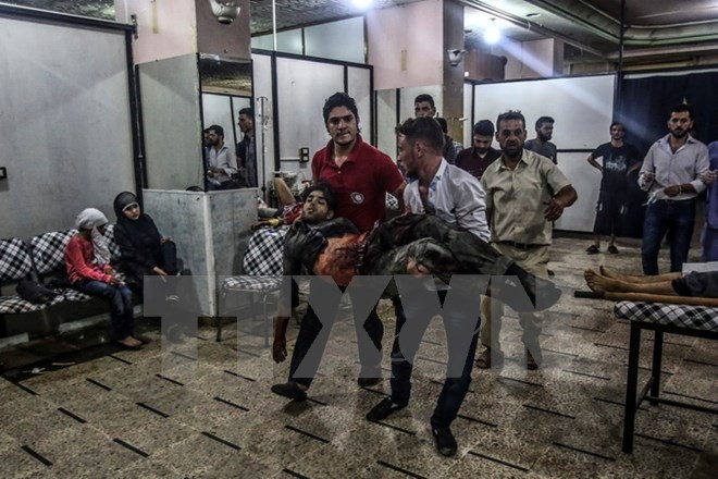 Bản tin 8H: Phiến quân nã đạn pháo vào thủ đô Syria Chuyển người bị thương trong các cuộc giao tranh tại Douma, ngoại ô Damascus, Syria ngày 9/7. (Nguồn: EPA/TTXVN)