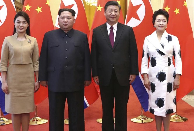 Vợ Kim Jong-un ‘đốn tim’ dân mạng Trung Quốc nhờ gu ăn mặc tinh tế Bà Ri Sol-ju (trái) xuất hiện cùng chồng, Chủ tịch Triều Tiên Kim Jong-un, trong lễ đón tiếp tại Bắc Kinh do vợ chồng Chủ tịch Trung Quốc Tập Cận Bình và bà Bành Lệ Viện chủ trì. Ảnh: Tân Hoa Xã