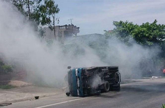 Tránh chiếc chăn bông, tài xế xe tải suýt chết Chiếc xe lật nghiêng và bốc khói nghi ngút (Ảnh: Dân trí)