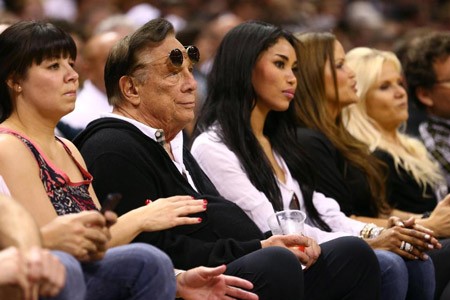 Ông chủ đội Los Angeles Clippers bị tố tội cưỡng hiếp Ông Donald Sterling (đeo kính) và bạn gái V. Stiviano xem một trận bóng rổ năm 2013 ở Texas.