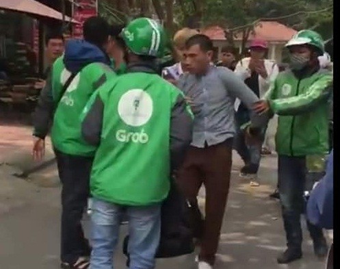 Khống chế người đàn ông trộm điện thoại của cô gái đi xe buýt Hình ảnh người đàn ông bị khống chế sau khi móc trộm chiếc điện thoại của nữ sinh. Ảnh cắt từ video.