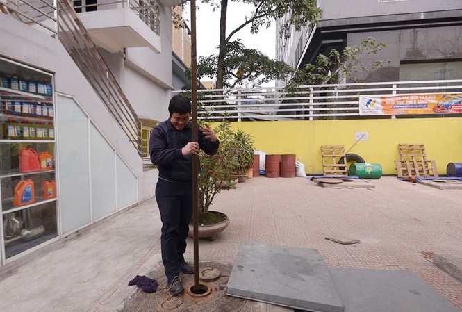Người dân hồ hởi đổ xăng với giá rẻ kỷ lục Tại Hà Nội: Trước giờ giảm giá xăng, nhân viên tại trạm xăng trên đường Nguyễn Lương Bằng (quận Đống Đa) đo kiểm tra lượng xăng còn lại ở dưới kho.
