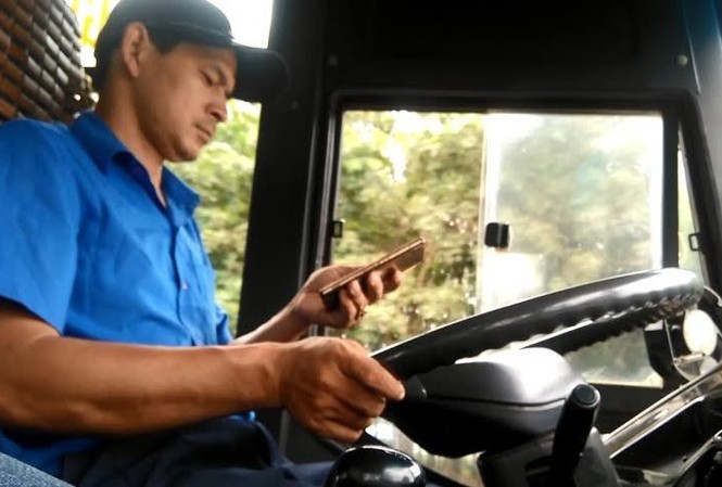 Tài xế vô tư nhắn tin khi xe buýt đang chạy nhanh Tài xế nhắn tin khi đang điều khiển xe buýt. Ảnh cắt từ clip.