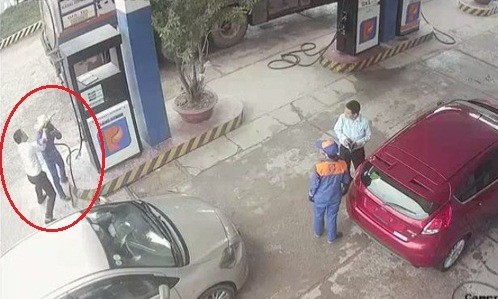 Khách đập vòi bơm vào đầu nhân viên cây xăng Camera an ninh ghi lại hình ảnh ông Đức dùng vòi bơm xăng tấn công nữ nhân viên. Ảnh cắt từ video.