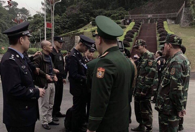 Trùm buôn lậu xuyên quốc gia trốn nã sang Trung Quốc Đối tượng Thọ (thứ 2, bìa trái, đầu trọc) chuẩn bị bàn giao từ Trung Quốc về Việt Nam .Ảnh: Duy Chiến