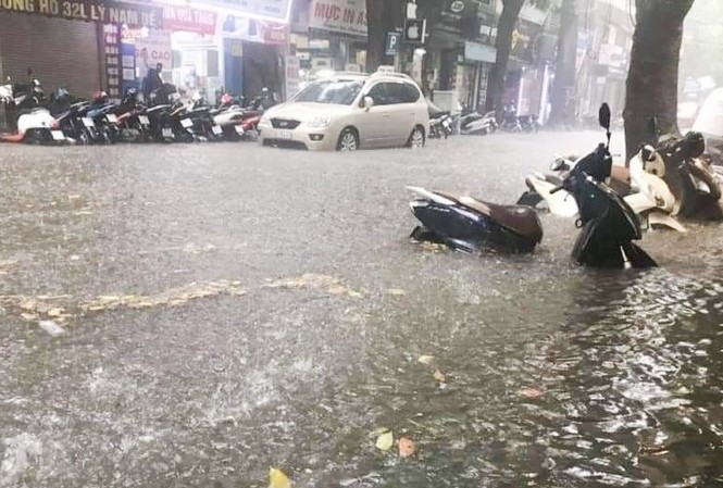 Lối thoát nào cho tình trạng hễ mưa là Hà Nội ngập? Mưa ngập cả bánh xe máy trên phố Hà Nội ngày 25/7 vừa qua