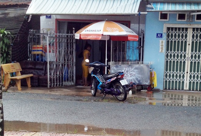 Truy bắt nghi can cúp cầu dao điện rồi đâm chết bạn nhậu Hiện trường án mạng trước căn nhà có chiếc dù che. Ảnh: Việt Tường
