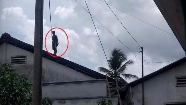 Thanh niên nghi ngáo đá, cố thủ 8 tiếng trên nóc nhà Thanh niên cố thủ trên nóc nhà từ 4 giờ sáng