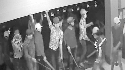 Nhóm côn đồ tràn vào quán karaoke đâm chém như phim hành động Các đối tượng dùng tay cản cửa cuốn, tay lăm lăm hung khí đe doạ nhân viên quán karaoke - Ảnh cắt từ clip