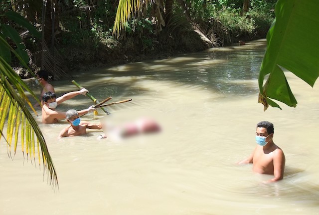 Chồng giết vợ, dìm xác dưới ao rồi tự vẫn Hiện trường nơi phát hiện người phụ nữ tử vong, hai chân bị trói. Ảnh: Công an Trà Vinh