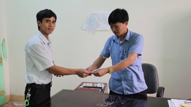 Phó Bí thư Đoàn xã tìm người đánh rơi vàng Anh Thành (trái) bàn giao chiếc vòng vàng cho chính quyền xã Cẩm Vịnh