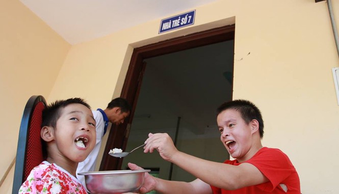Về Ba Vì thăm trẻ chùa Bồ Đề Hai em nhỏ tự đút cơm cho nhau ăn rất ngon lành. Ảnh: Minh Đức