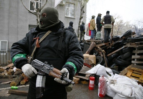Bản tin 8H: Liên Hợp Quốc họp khẩn về vấn đề Ukraine Một tay súng đứng cạnh hàng rào chắn, bên ngoài trụ sở cảnh sát ở Sloviansk. Ảnh: Reuters