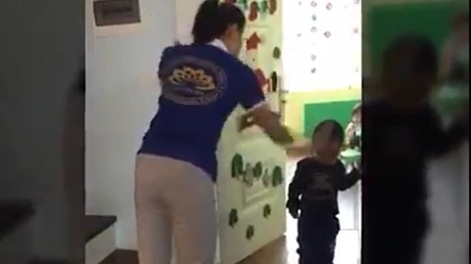 Bộ GD&ĐT đề nghị xử lý nghiêm giáo viên lấy dép đánh vào đầu trẻ Giáo viên lấy dép đánh vào đầu trẻ. Ảnh cắt từ clip.