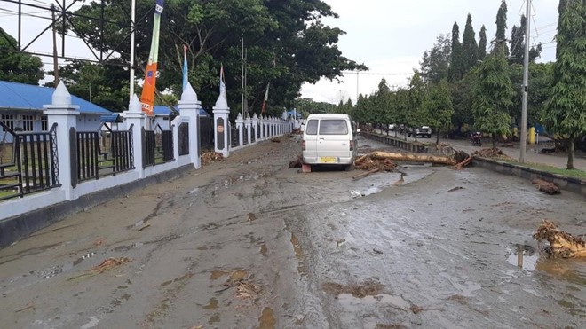 Ít nhất 42 người chết do lũ quét ở Indonesia Bùn đất và các cây gỗ vương vãi trên mặt đường sau đợt lũ lụt. Ảnh: Twitter / Jayapura Regional Police.