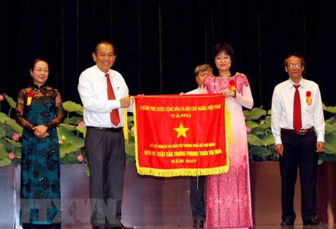 TP.HCM kỷ niệm 70 năm ngày Bác Hồ ra Lời kêu gọi Thi đua ái quốc Phó Thủ tướng Thường trực Chính phủ Trương Hòa Bình tặng Cờ thi đua cho đại diện Sở Kế hoạch và Đầu tư Thành phố. (Ảnh:Hoàng Hải/TTXVN)