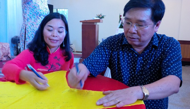 “Tổ quốc không chỉ là tình yêu thiêng liêng…” Nhà thơ Quế Mai cùng nhạc sỹ Đinh Trung Cẩn cùng ký tên lên lá cờ Tổ quốc trong buổi ra mắt tập thơ “Tổ quốc gọi tên mình”.