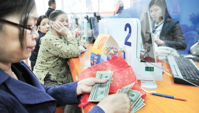 Khách hàng chuyển sang gửi tiền đồng? Tỷ giá sẽ tăng vào cuối năm do tâm lý khiến nhiều tổ chức và cá nhân có thể “găm” USD. Ảnh: Hồng Vĩnh.