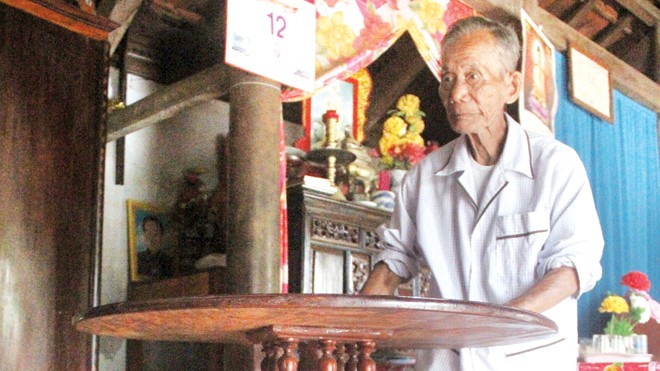 Truyền bí kíp bàn xoay 'ma thuật' Nghệ nhân Đinh Thạch bên chiếc bàn xoay do cụ chế tác. Ảnh: H. Văn.