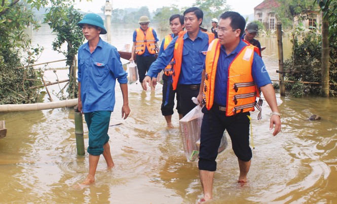 Tình người vùng rốn lũ Bí thư Tỉnh Ðoàn Hà Tĩnh Nguyễn Thế Hoàn (ngoài cùng bên phải) cùng đoàn viên, thanh niên mang quà tặng bà con vùng lũ Hương Khê.