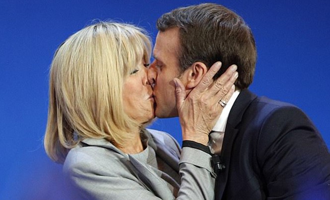 Chuyện tình cảm động của ứng viên tổng thống Pháp Ông Emmanuel Macron và vợ hôn nhau trước mặt những người ủng hộ trong chiến dịch tranh cử tháng trước. Ảnh: AP.