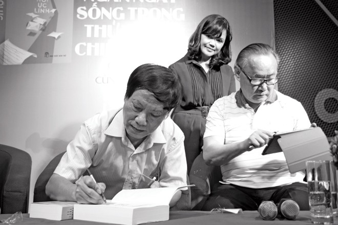 Câu chuyện chiến tranh với tác giả 'Hồi ức lính' Vũ Công Chiến ký tặng sách trong buổi ra mắt “Hồi ức lính” năm ngoái. Bên cạnh là vợ anh và nhà văn Ngô Thảo. Ảnh: Nguyễn Đình Toán.