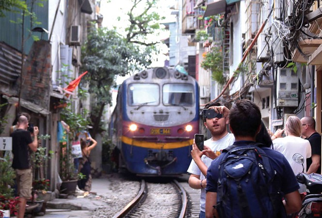 Cục trưởng Đường sắt: 'Trong nhà có ông già bị ốm' Tàu hỏa đi xuyên qua “xóm đường tàu” kéo dài khoảng hơn 2 km từ Khâm Thiên, Phùng Hưng (Hà Nội). Ảnh: Hồng Vĩnh.