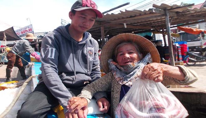 Các cụ già đi xin cá Bà Trần Thị Chướng may mắn được ngư dân cho hàng chục ký cá từ chiếc thuyền vừa trở về.