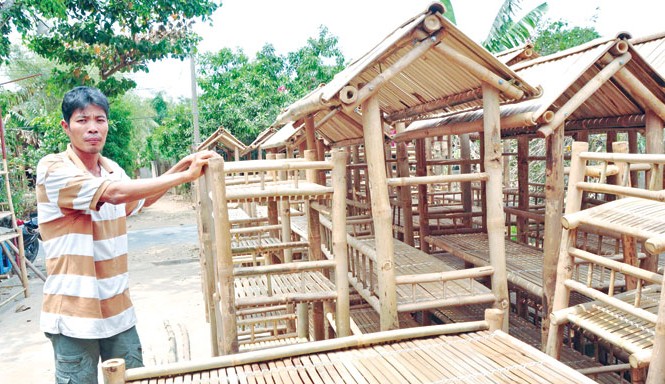 Người Khmer xuất khẩu giường tre Ông Trì Cảnh bên cạnh các sản phẩm của mình. Ảnh: Hòa Hội