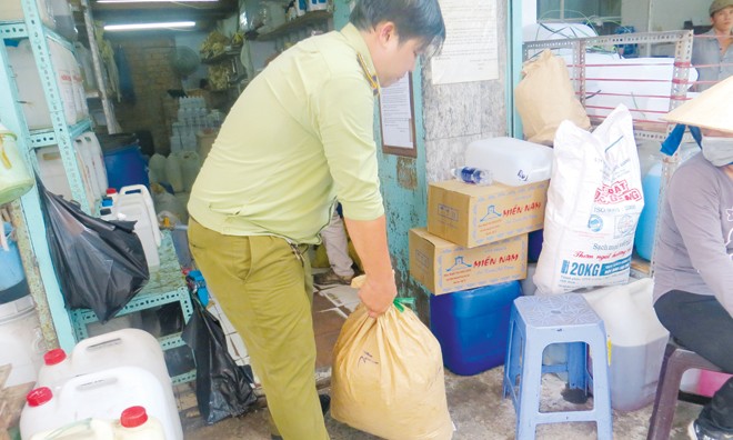 Tổng tấn công thực phẩm bẩn Chi cục Quản lý thị trường thành phố tịch thu hóa chất của một cửa hàng tại chợ Kim Biên hôm 27/5.
